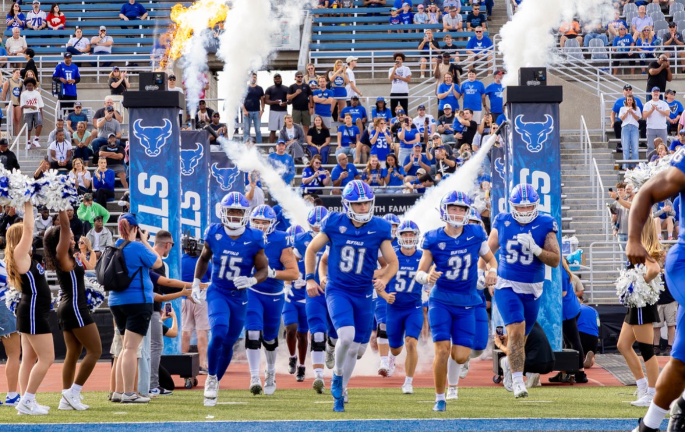 A football team running onto the field