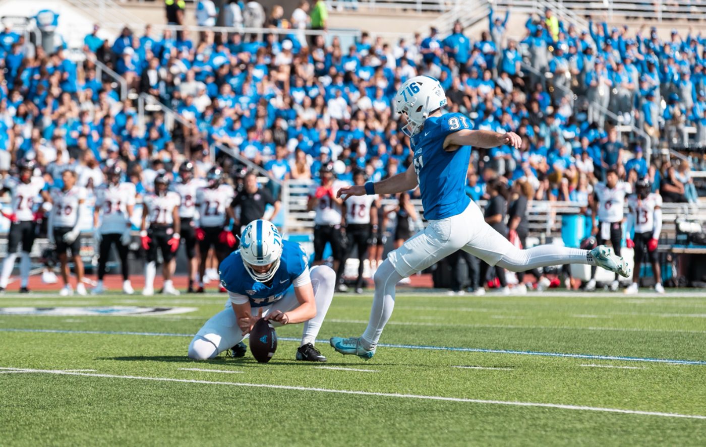 A kicker making contact with the ball off a hold